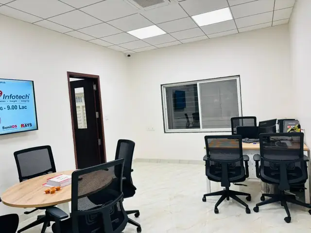 Meeting room at Rays EdTech with a round table and a screen displaying a student placement update
