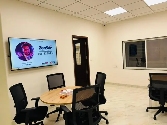 Discussion room at Rays EdTech with a round table and a screen showing a ZenSar Technologies placement announcement