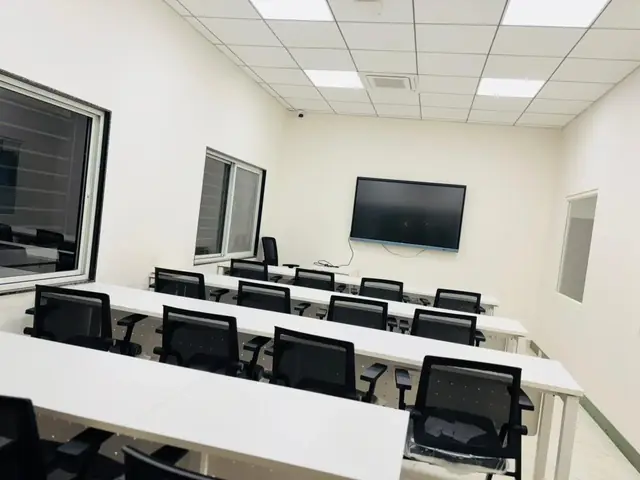 Empty classroom at Rays EdTech with rows of desks facing a wall-mounted smart screen